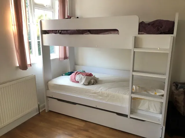 White bunk bed with pull-out bed assembled in a child's bedroom