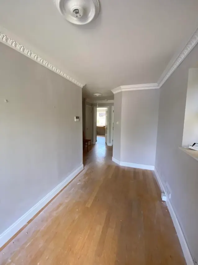 Long hallway with oak flooring and freshly painted walls