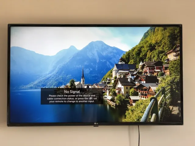 Flat-screen TV wall mounted level on a plain wall with cables hidden